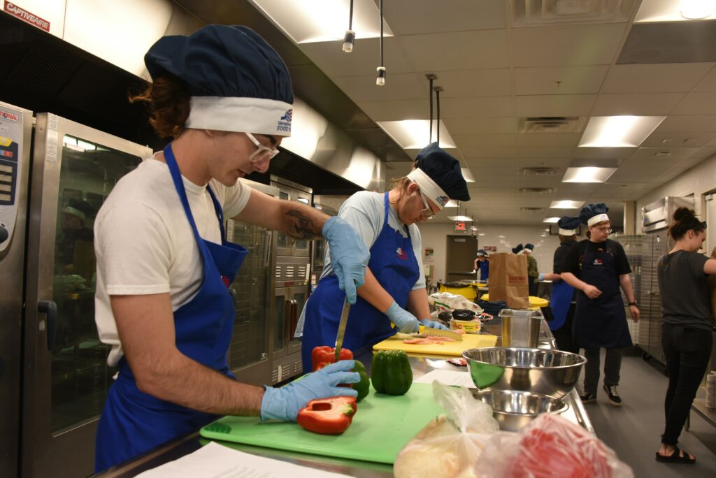 Cooking Merit Badge participant preparing ingredients and following a recipe in a safe cooking environment.